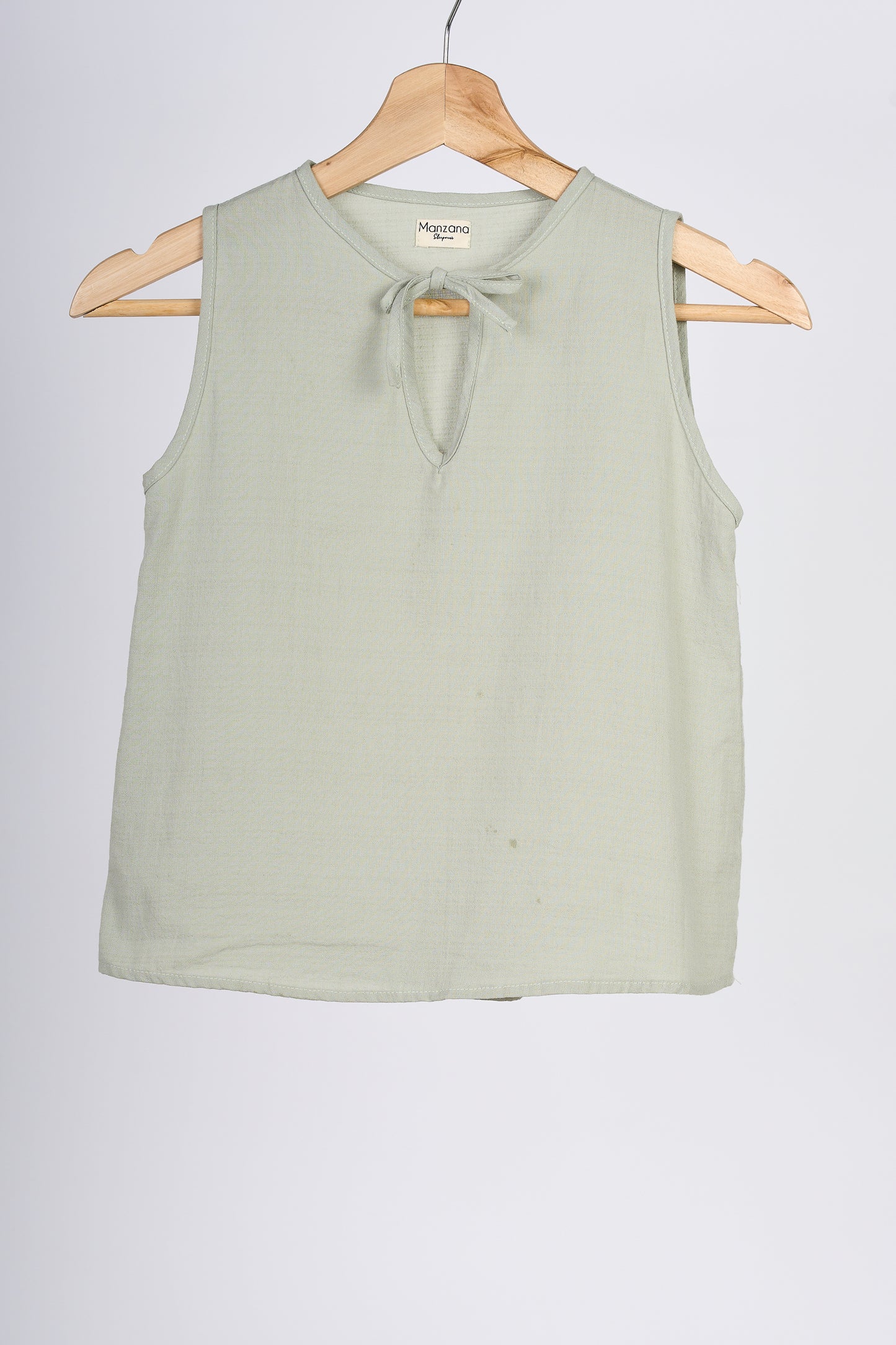 Blusa color verde, en colgador marrón