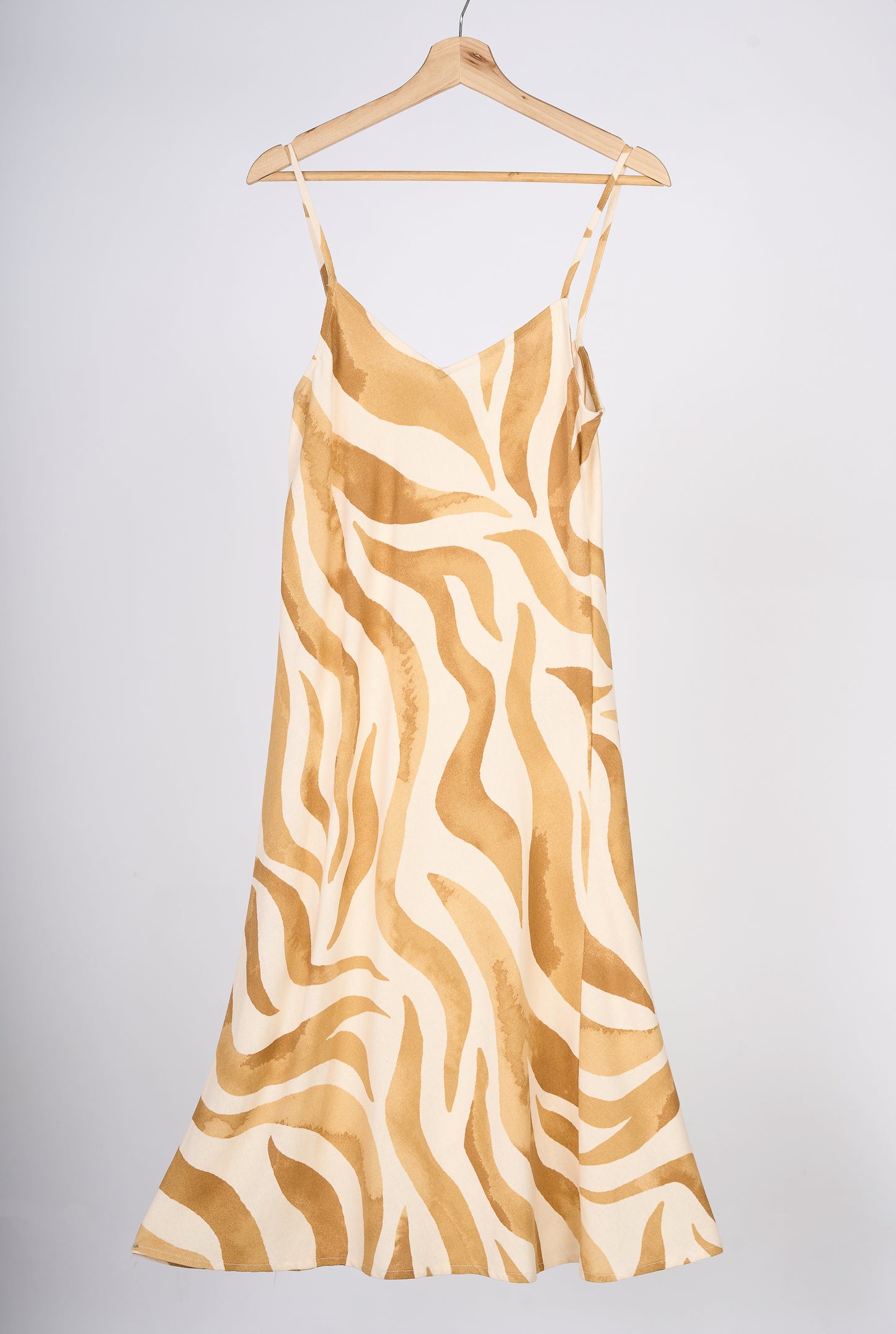 Slipdress de flores color mostaza, en colgador marrón.