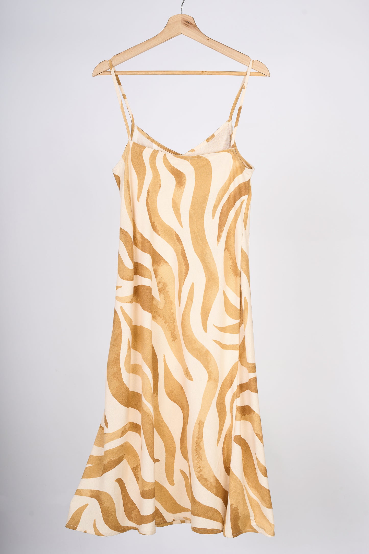 Slipdress de flores color mostaza, en colgador marrón.