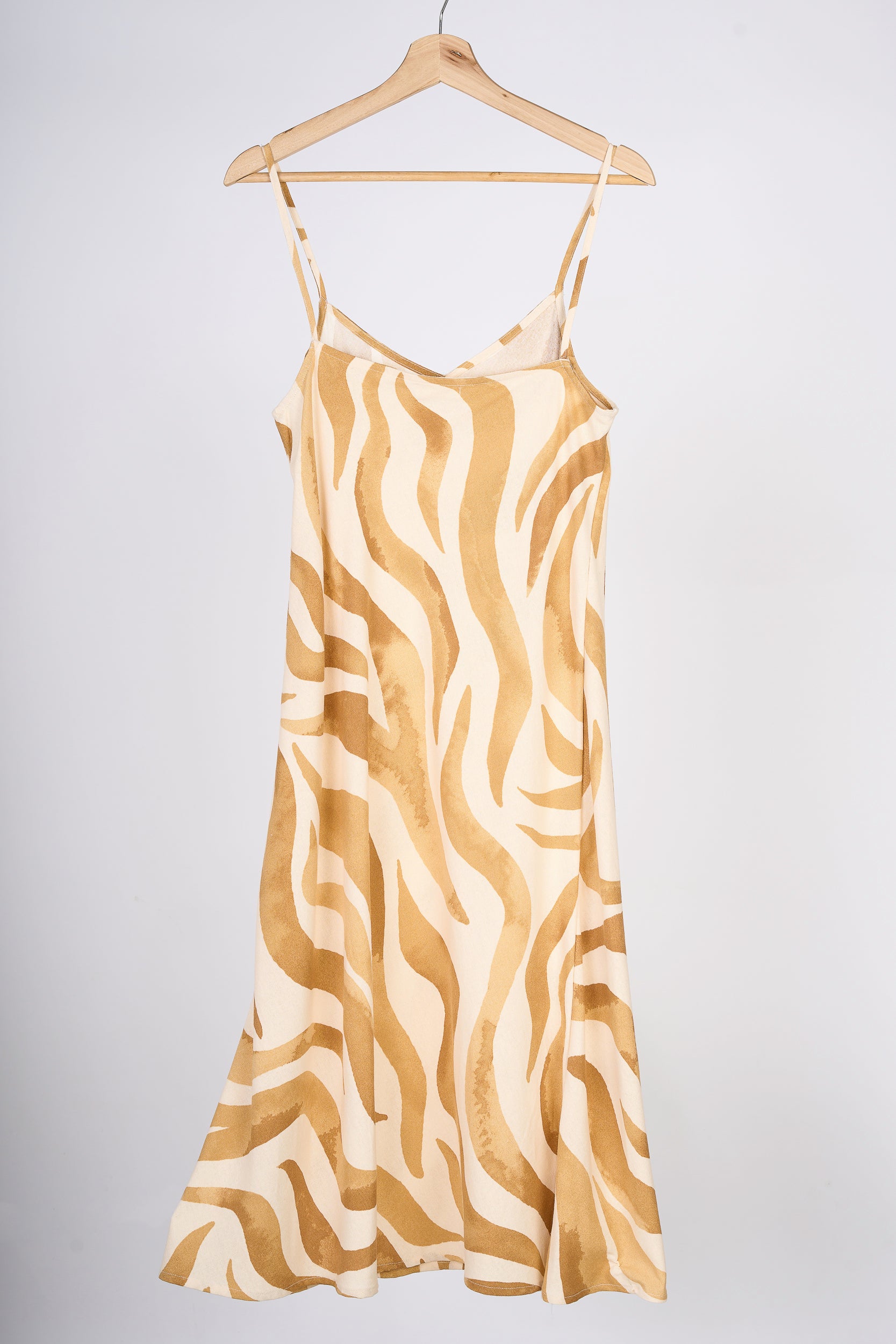 Slipdress de flores color mostaza, en colgador marrón.