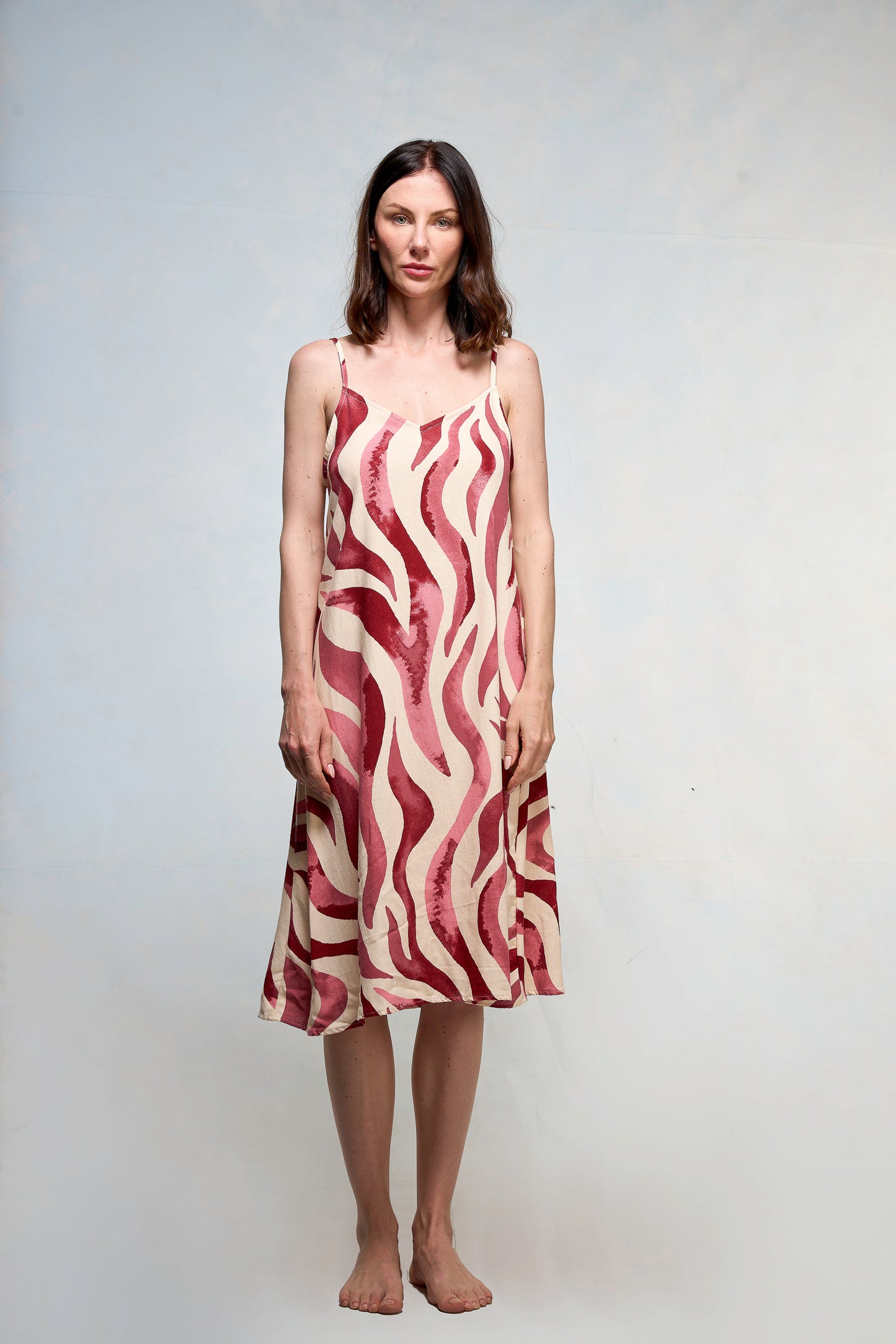 Mujer vestida en slipdress con print de hojas fucsia