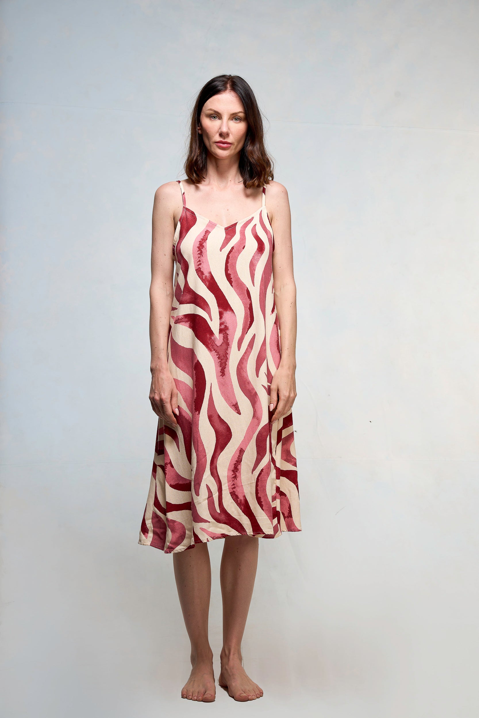 Mujer vestida en slipdress con print de hojas fucsia