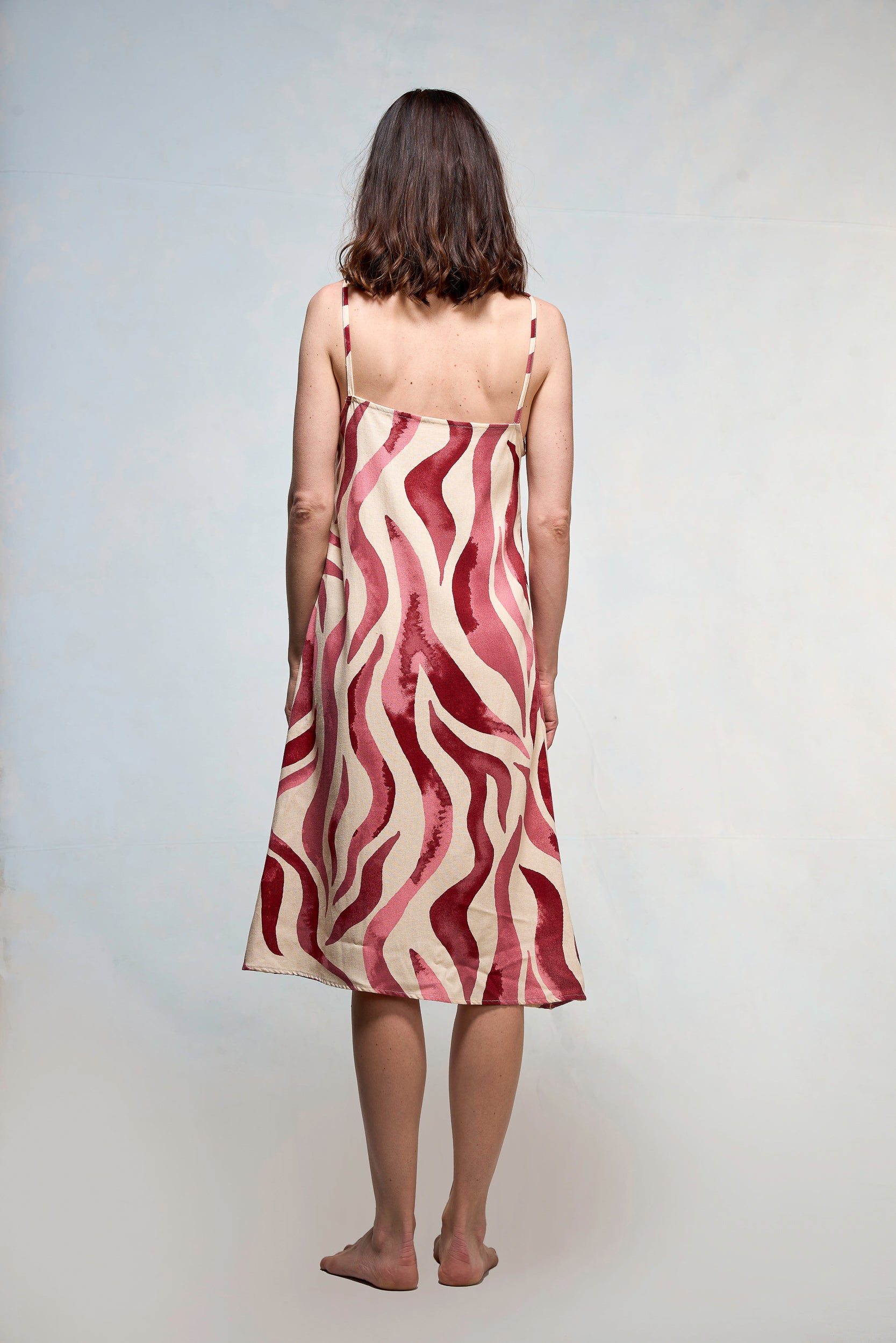 Mujer vestida en slipdress con print de hojas fucsia